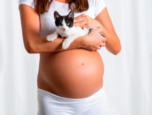 Imagen mujer embarazada cargando un gato
